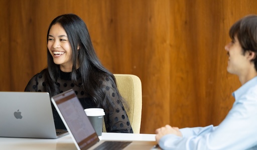 Students sitting around a desk with laptops